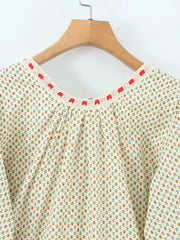 Detail of the O-neckline and decorative trim on a mini dress.