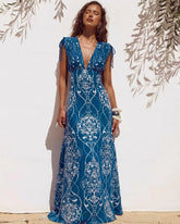 Woman wearing blue and white architectural print two-piece swimwear set with a maxi skirt.
