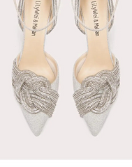 Pair of silver high-heeled shoes with intricate designs on a white background