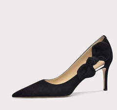 Black high-heeled shoe with a bow detail on a light gray background