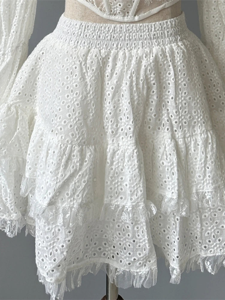 White lace dress with ruffled sleeves on a mannequin against a gray background