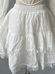 White lace dress with ruffled sleeves on a mannequin against a gray background