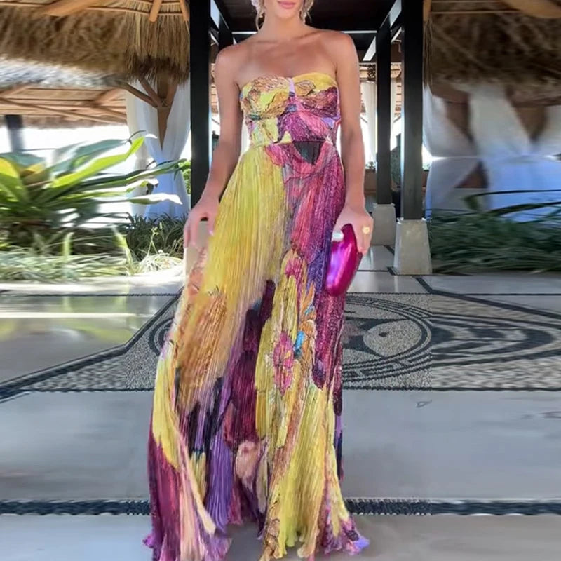 Woman in a colorful strapless dress holding a clutch in an outdoor setting.