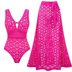Deep V-neck one-piece swimsuit with eyelet details and tie-waist midi skirt in pink.