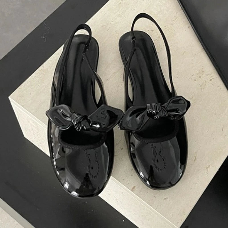 Black patent bow slingback pumps with round toe