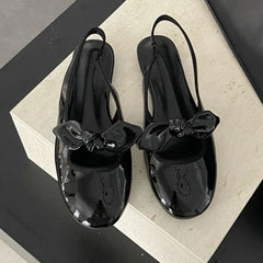 Black patent bow slingback pumps with round toe