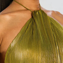 Green pleated top worn by a person on a light background
