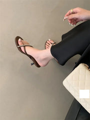 Person wearing a high-heeled sandal on a plain background