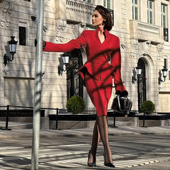 Woman in a red outfit standing in front of an elegant building