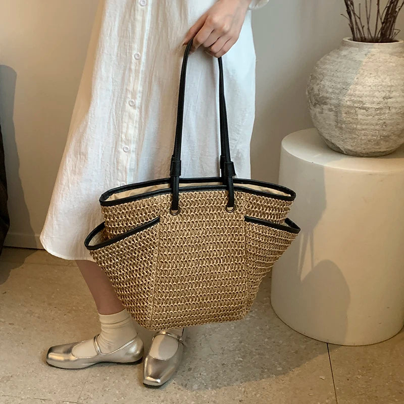 Person holding a woven basket bag indoors with a neutral background