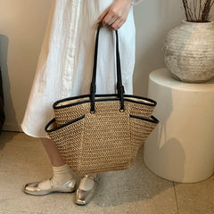 Person holding a woven basket bag indoors with a neutral background