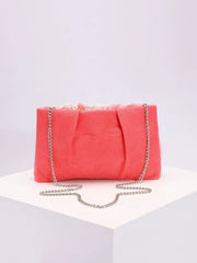 Pink clutch bag with a chain strap on a light gray background