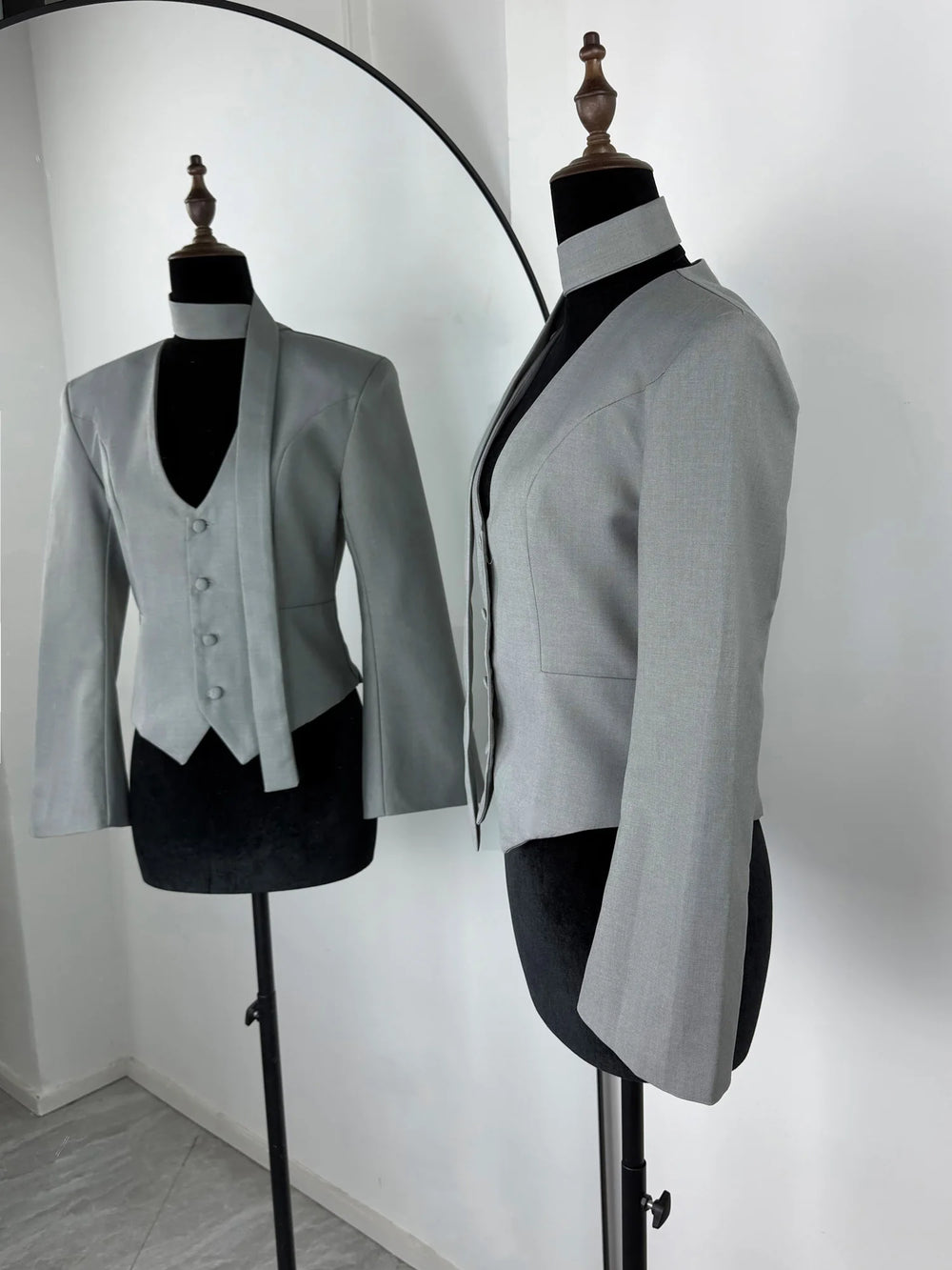 Gray blazer on a mannequin against a white background