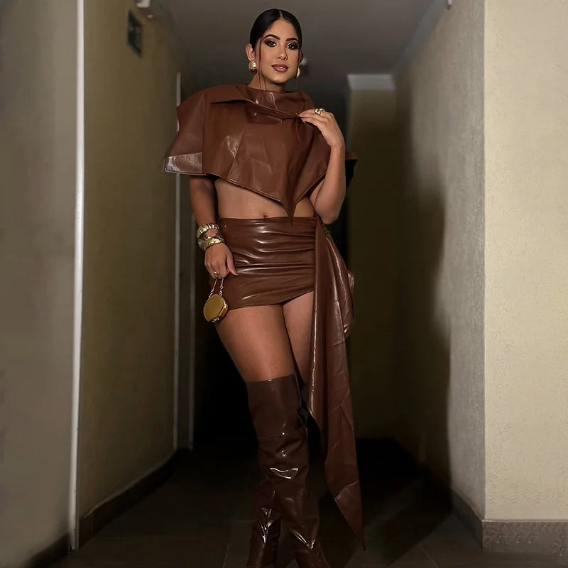 Woman in a brown outfit standing in a dimly lit hallway.