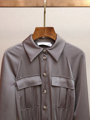 Gray jacket on a wooden hanger against a beige background