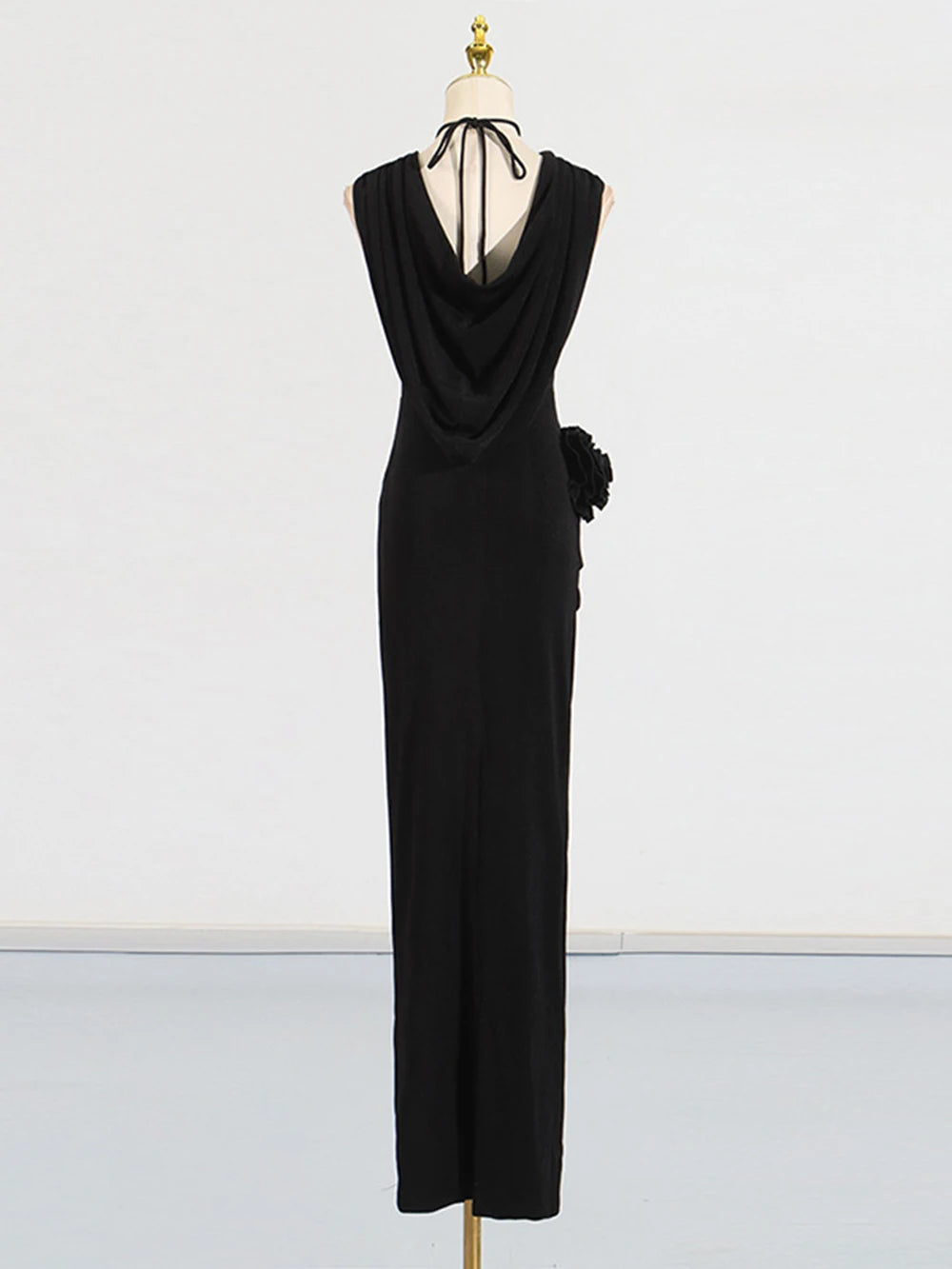 Black evening gown on a mannequin against a white background