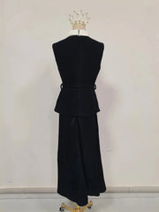 Black dress on a mannequin against a plain background