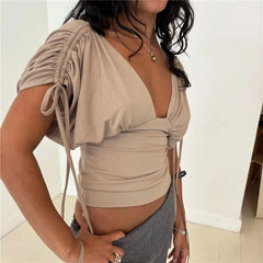 Side view of a beige deep V neck ruched drawstring sleeve top