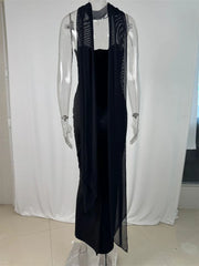 Black dress with sheer panels on a mannequin against a white curtain background