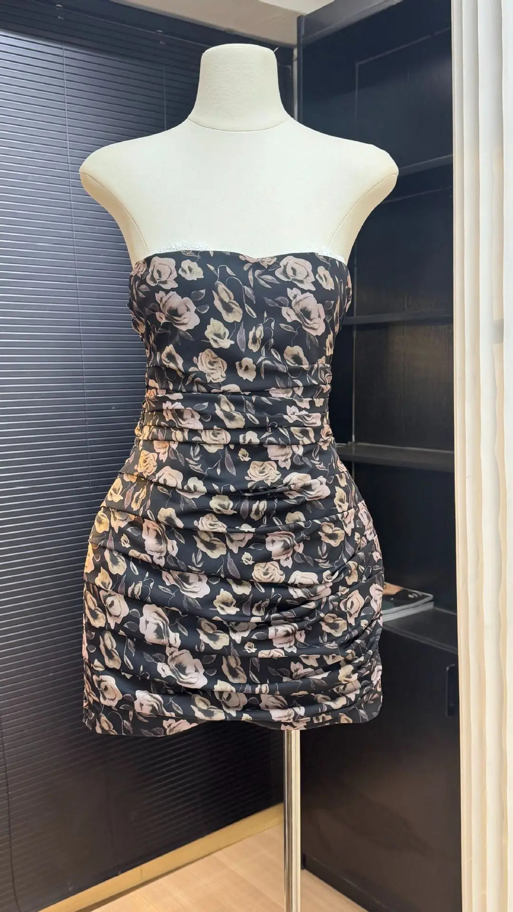Floral strapless dress on a mannequin against a dark background