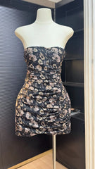 Floral strapless dress on a mannequin against a dark background