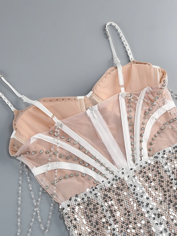 Delicate beige lace bra with silver embellishments on a gray background