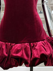 Red velvet dress on a mannequin with a blurred indoor background