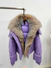 Purple coat with a fur collar hanging on a rack against a white wall.