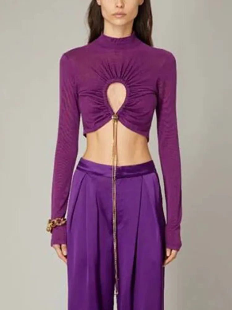Purple long-sleeve top with cut-out design and matching pants on a neutral background