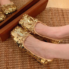 Sparkling sequin bow ballet flats on a person's feet