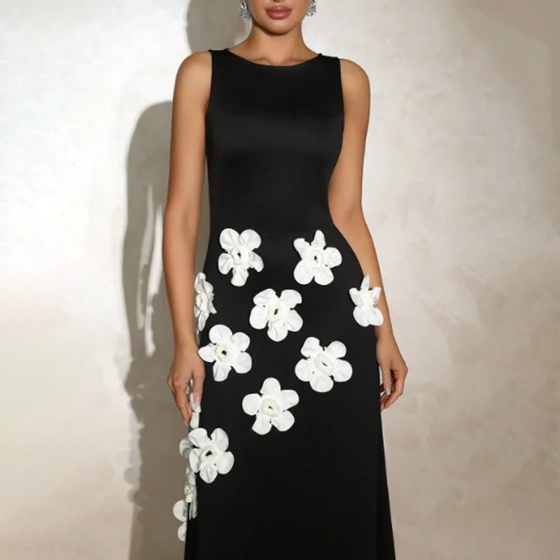 Black dress with white floral patterns on a plain background