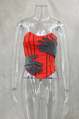Mannequin wearing a red corset with gray gloves on a plain background