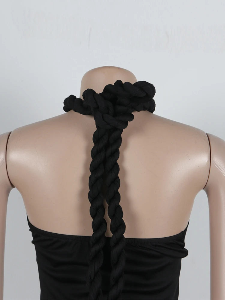 Mannequin with a black dress and braided hair accessory on a plain background
