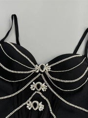 Black dress with intricate silver embellishments on a gray background