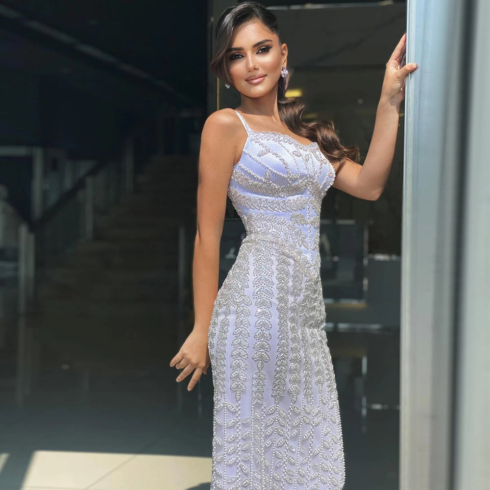 Woman in a silver beaded dress standing outdoors.
