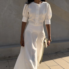 Woman wearing a white outfit with a plain background