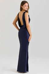 Navy blue evening gown with open back and slit on a white background
