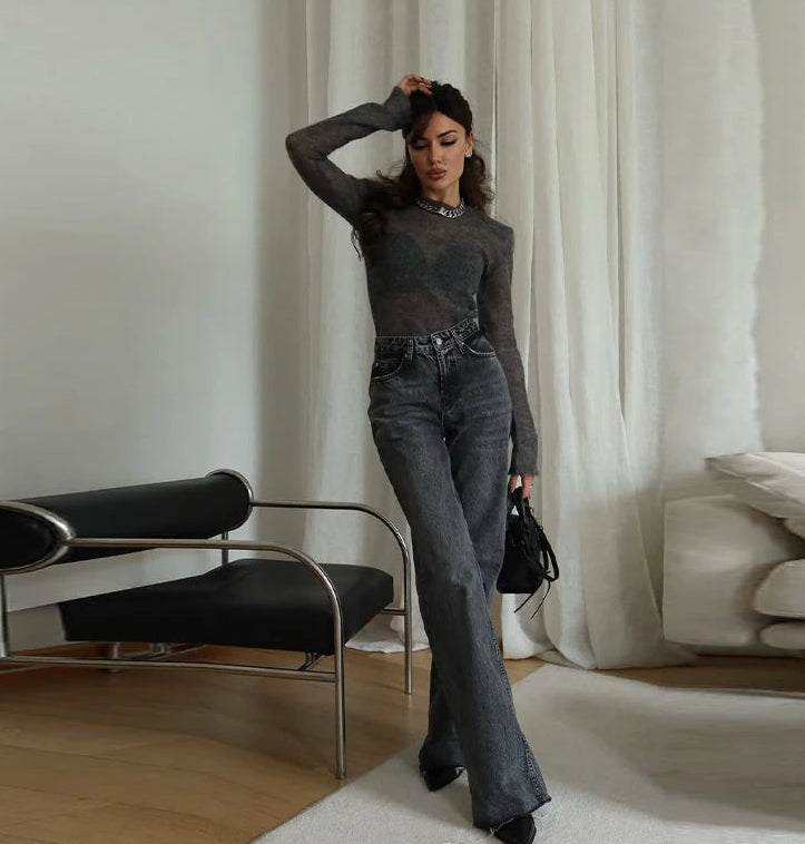 Woman in a stylish outfit standing in a modern living room.