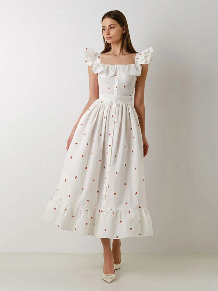 Woman wearing a white dress with ruffled sleeves against a plain background