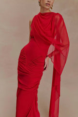 Red evening gown with sheer sleeves on a beige background