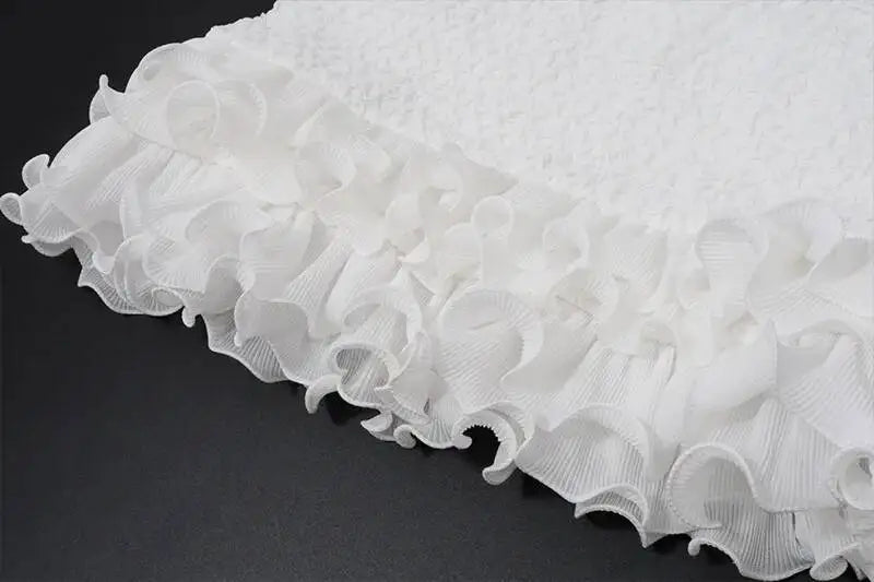 Close-up of white ruffled fabric on a dark background