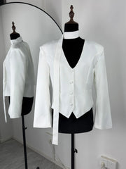 White tuxedo jacket and vest on mannequins against a white wall.