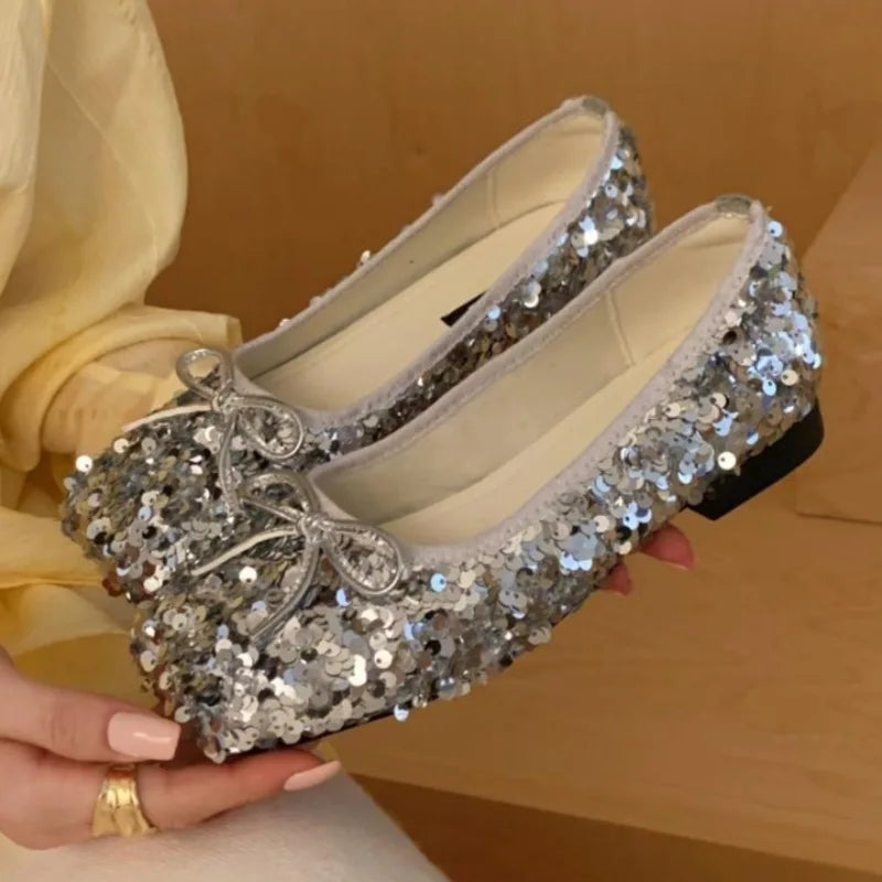 Close-up of silver sparkling sequin bow ballet flats