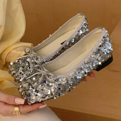 Close-up of silver sparkling sequin bow ballet flats