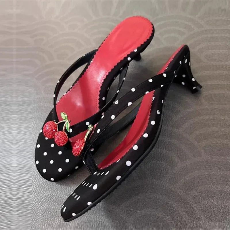 Polka dot kitten heel flip flops with cherry embellishment angled view