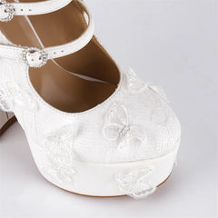 White embroidered shoe with butterfly designs on a light gray background