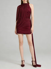 Burgundy halter neck dress with a side slit on a gray background