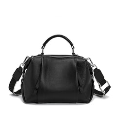 Black leather handbag with a shoulder strap on a white background