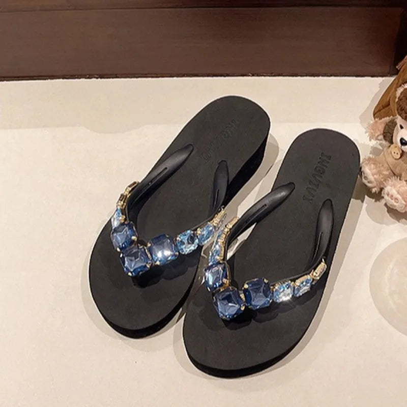 Embellished wedge sandals in black with blue gemstones