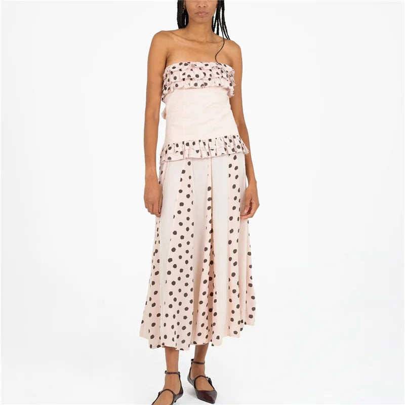 Woman wearing a strapless dress with polka dot top and skirt on a white background